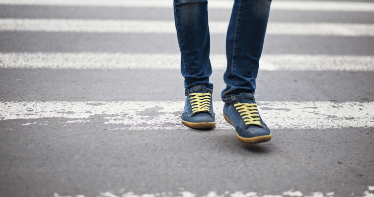 Feet of pedestrian walking in a crosswalk